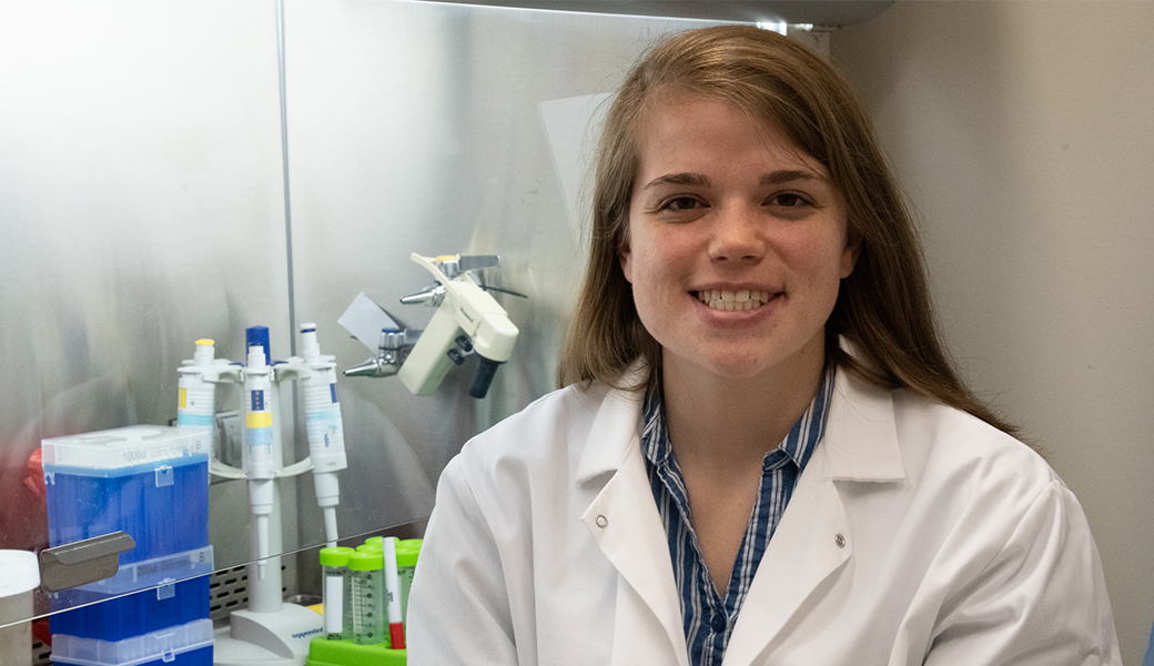 graduate student Cassie Russell in front of biological safety cabinet in Dennis Kyle's laboratory at the University of Georgia