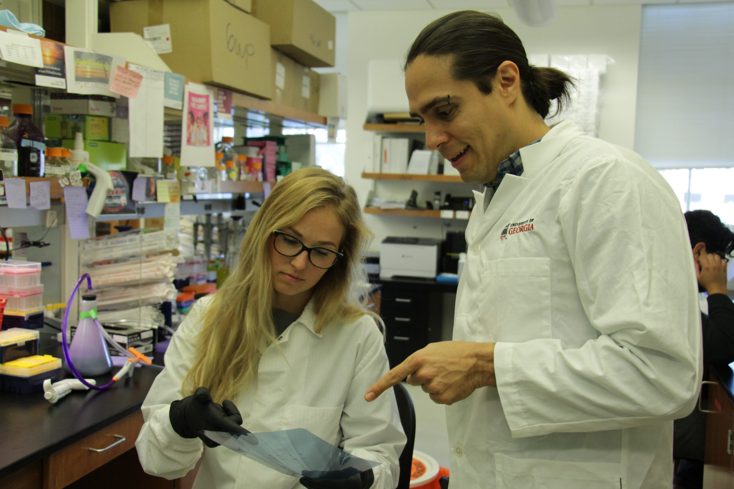 photo of Madelaine Usey (left) and Diego Huet (right) in the lab